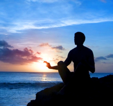 Image d'un coucher de soleil avec une personne en position de méditation